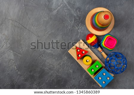 Space for text. Baby play development concept. Flat lay objects baby toys for development background concept. Table top view variety toys for children play education on dark grey black desk.