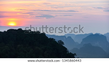 Stunning sunset behind some beautiful limestone mountains. Picture taken from the Tiger Cave Temple (Wat Tham Sua) Krabi, Thailand.