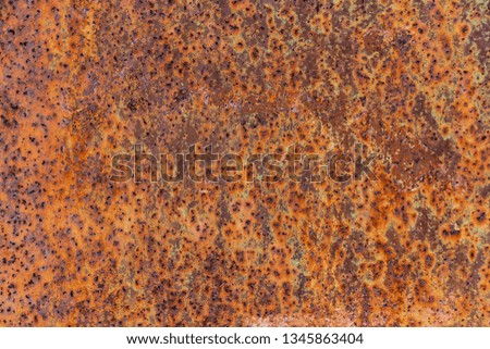 Beautiful horizontal texture of yellow and green and brown metal sheet with orange rust and holes in the photo