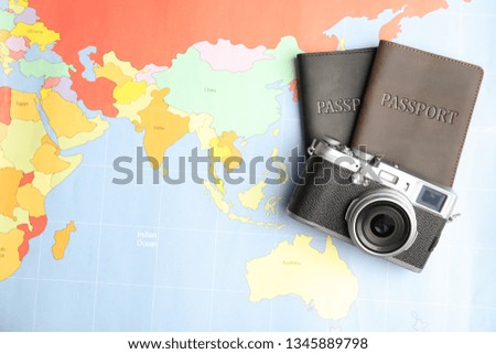 Passports and camera on world map, top view. Travel agency
