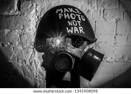 Art picture of military gas mask and green helmet on white brick wall with shadows, the inscription make photo not war on Fatherland defender day. Сoncept of calling world peace without hatred and war