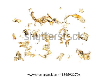 Flakes sheets of gold foil isolate on white background. Luxurious shine for celebration, celebration, fun. Top view, flat lay.