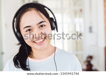 Asian cute young teen smiling with headphone enjoy music looking camera.