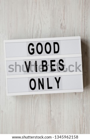 'Good vibes only' words on modern board over white wooden surface, top view. From above, overhead, flat lay.