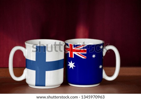Australia and Finland flag on two cups with blurry background
