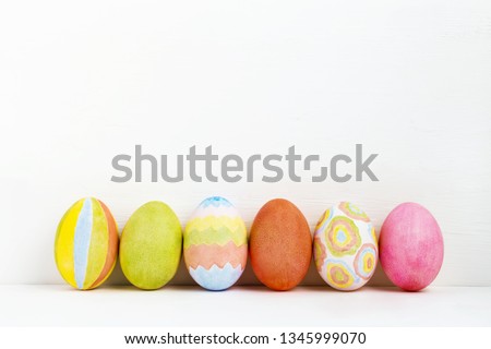 Colorful handmade Easter eggs on white background. Esater eggs in row over white background