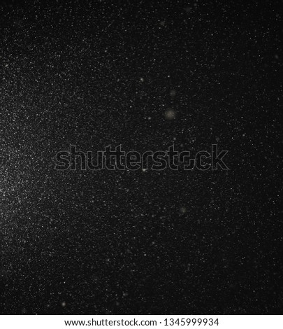 Snow flies in the sky at night as a background.