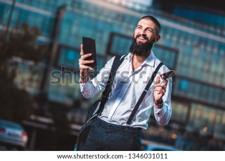 Portrait of a young caucasian businessman holding a tablet and credit card outdoor
