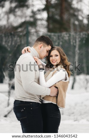 Winter love story on ice. Beautiful young guy and girl skating on ice