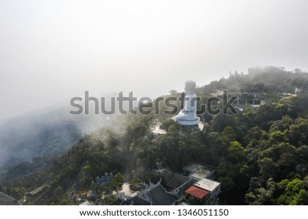 Aerial view of Linh Ung Pagoda with a giant buddha statue among green trees and sea clouds floating on the top of Ba Na mountain, Da Nang, Vietnam. Near Golden bridge