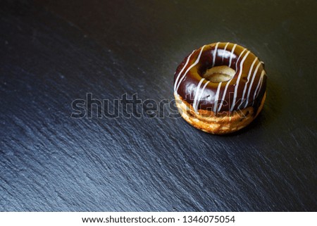 chocolate donut on a stone surface background and space for your advertising. dark retro style background.Collection for celebration design.Sweet dessert