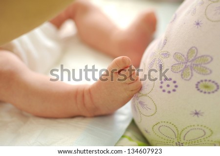 newborn child's foot on bed