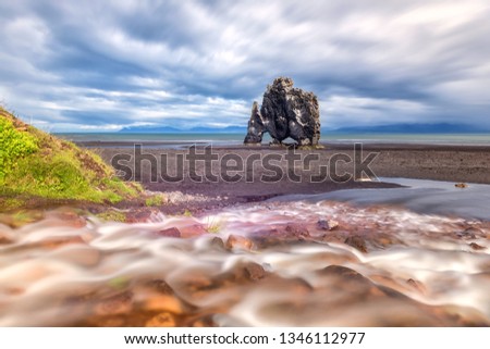 Hvinserkur basalt stack in Iceland, spectacular rock in the sea with the shape of a dragon or dinosaur who is drinking. Famous tourist attraction in Vatnsnes, travel background