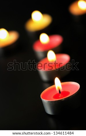 Group of candles burning on black