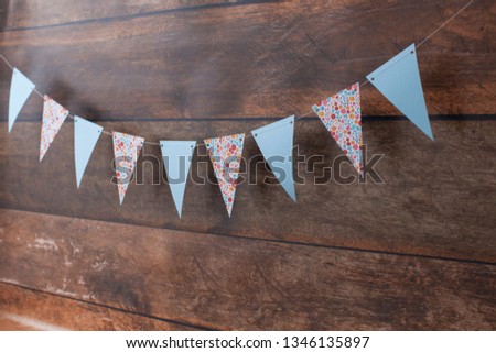 Wish list or shopping overview for pregnancy and baby shower. View from above. Braun wooden older board. Flags for birthday party, inspiration. Handmade and colorful. 