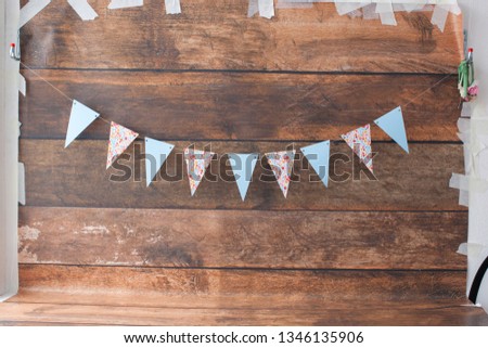 Wish list or shopping overview for pregnancy and baby shower. View from above. Braun wooden older board. Flags for birthday party, inspiration. Handmade and colorful. 