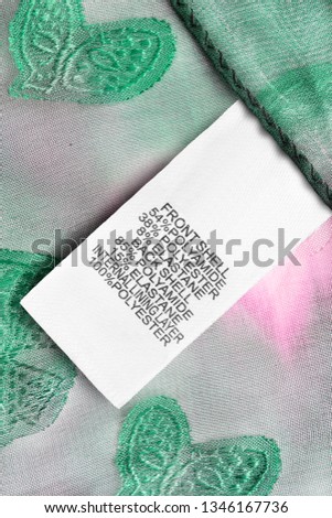 Composition clothes label on green and pink textile background