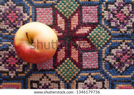 One apple on a table on a patterned tablecloth. Background with copy space. Flat lay, Top view. Fairy sleeping Beauty apple