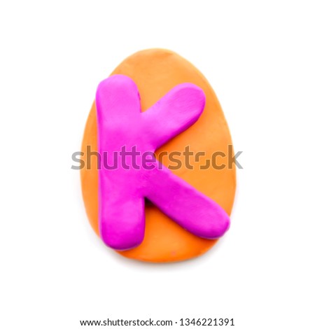 Plasticine letter K in the shape of an Easter egg on a white background