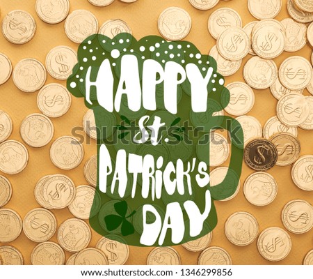 top view of shiny golden coins with dollar signs near happy st patrick day lettering on orange background 