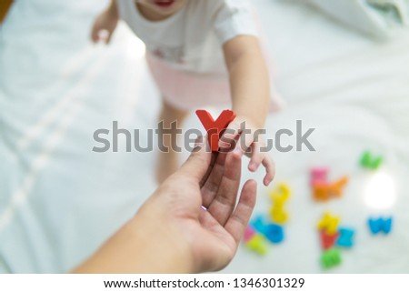 Asian baby Playing ABC Letters on a bed Royalty-Free Stock Photo #1346301329