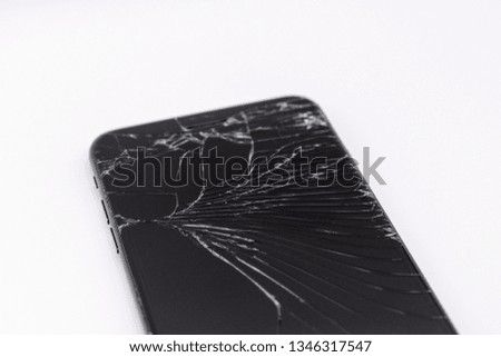 Black modern smart phone with a broken screen on a white background