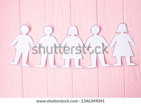 close up of paper people on pink background 