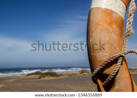 Old worn life bouy in a surreal desert environment next to the coast line of Fuerteventura in Spain. 