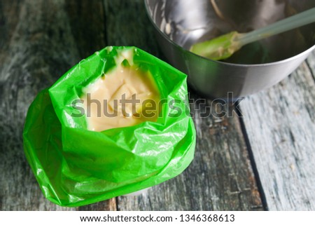 Preparing choux pastry for eclairs, dough in a green bag for pipping Royalty-Free Stock Photo #1346368613