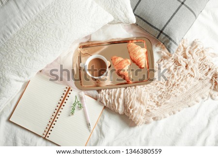 Cozy bed with coffee cup and croissant on golden food tray , Top view breakfast in bed , Holiday morning.