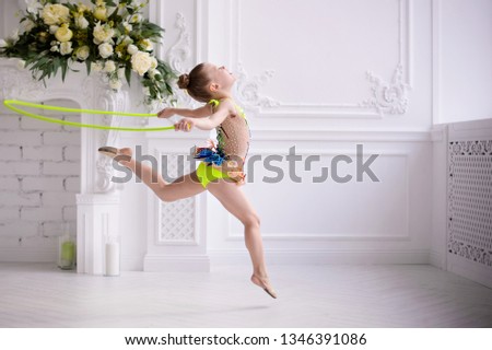 Little girl gymnast, performs various gymnastic and fitness exercises. The concept of childhood and sport, a healthy lifestyle.