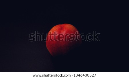 Minimal concept, A peach  in dark room, object isolate with background,Shining portrait peach in darkness.  