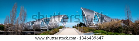 Modern Arganzuela Footbridge in downtown Madrid, Spain outdoors at Madrid Rio green park across the Manzanares river on a warm spring day. Famous modern metal bridge in a form of a spiral at a park.