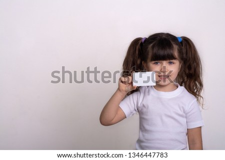 Little pretty girl holding a credit card. Paying, money or savings concept. 