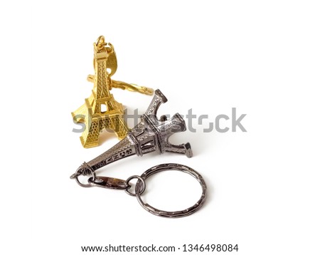 Two metal souvenir keychains from France in the form of Eiffel tower, gold-plated and metal color, isolated on white background