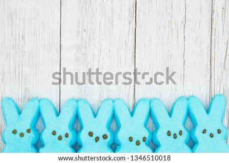 Blue candy bunnies on weathered whitewash textured wood background with copy space for your Easter message Royalty-Free Stock Photo #1346510018