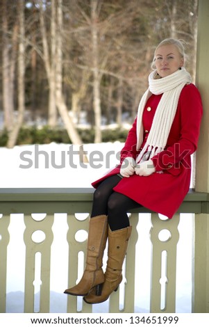 Woman in red coat sit at terrace boundary