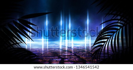 Dark street with neon lights and spotlights. Abstract rays and lines of light in the dark. Light pyramid, a triangle in the center. Reflection in the wet pavement of city lights.  tropical leaves.