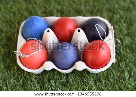 Cute creative photo with easter eggs, some eggs as the Easter Bunny in paper box on green background