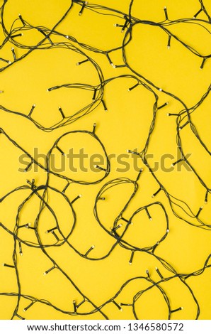 Christmas lights on a bright yellow background. Bright background for design.