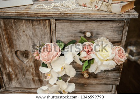 close up photo of a wedding decor: a vintage wooden cupboard decorated with flowers