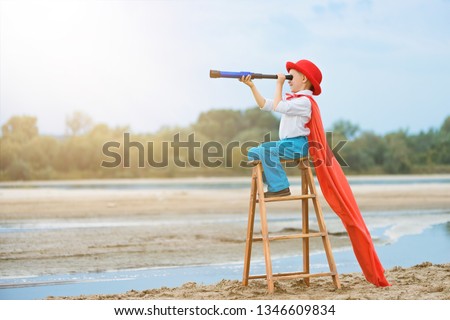 little boy explorer  with a telescope on a ladder, outdoor,side view,  Royalty-Free Stock Photo #1346609834