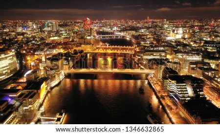 Aerial drone panoramic night shot of iconic financial district and skyscrapers in City of London over river Thames, United Kingdom