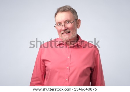 man in red shirt wearing glasses smiling confident