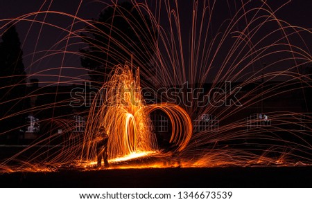 Steelwool photography in an abandonned lot. Model was wearing a full-blown fireman suit, and three people were spinning.