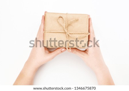 Gift boxes Packed in Kraft paper in the hands of a girl on a white background. Concept for advertising for holidays: birthday, Christmas                        