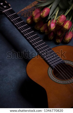 guitar on a blue background with tulips 