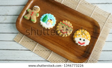Plate with tasty Christmas cookies on wooden table  