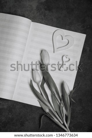 black and white photo of flowers and music note paper