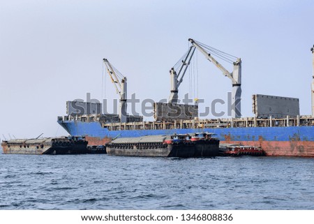 A large cargo ship is moving in the sea and moving goods.